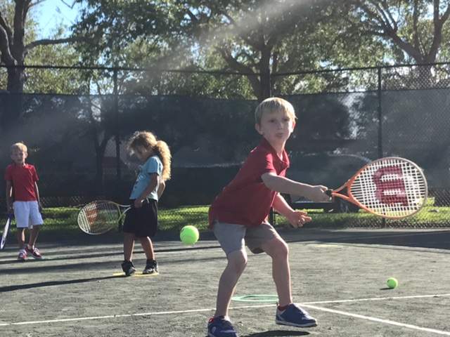 Young children playing tennis